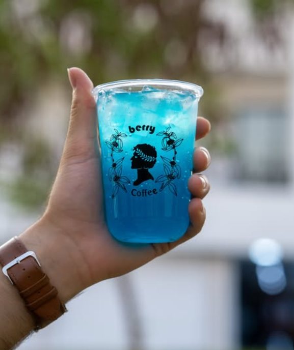 A bright blue iced drink in a Berry Coffee cup