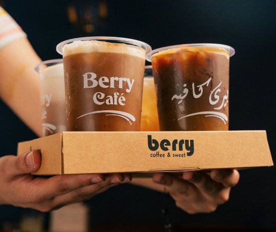 Iced coffees in Berry Café cups with English and Arabic lettering